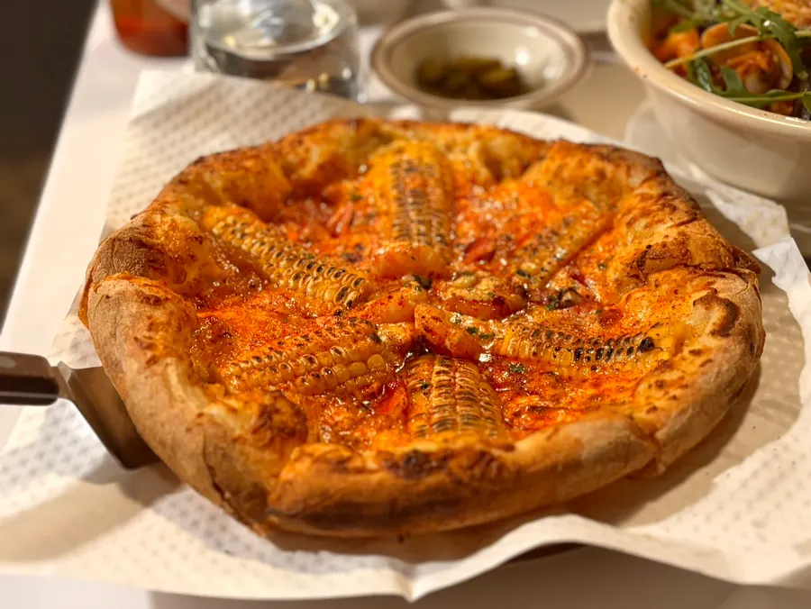 테이블에 서빙된 옥수수피자 한 판