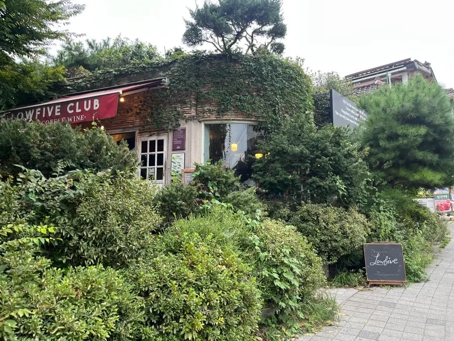 Exterior of the Low Five flagship surrounded by greenery