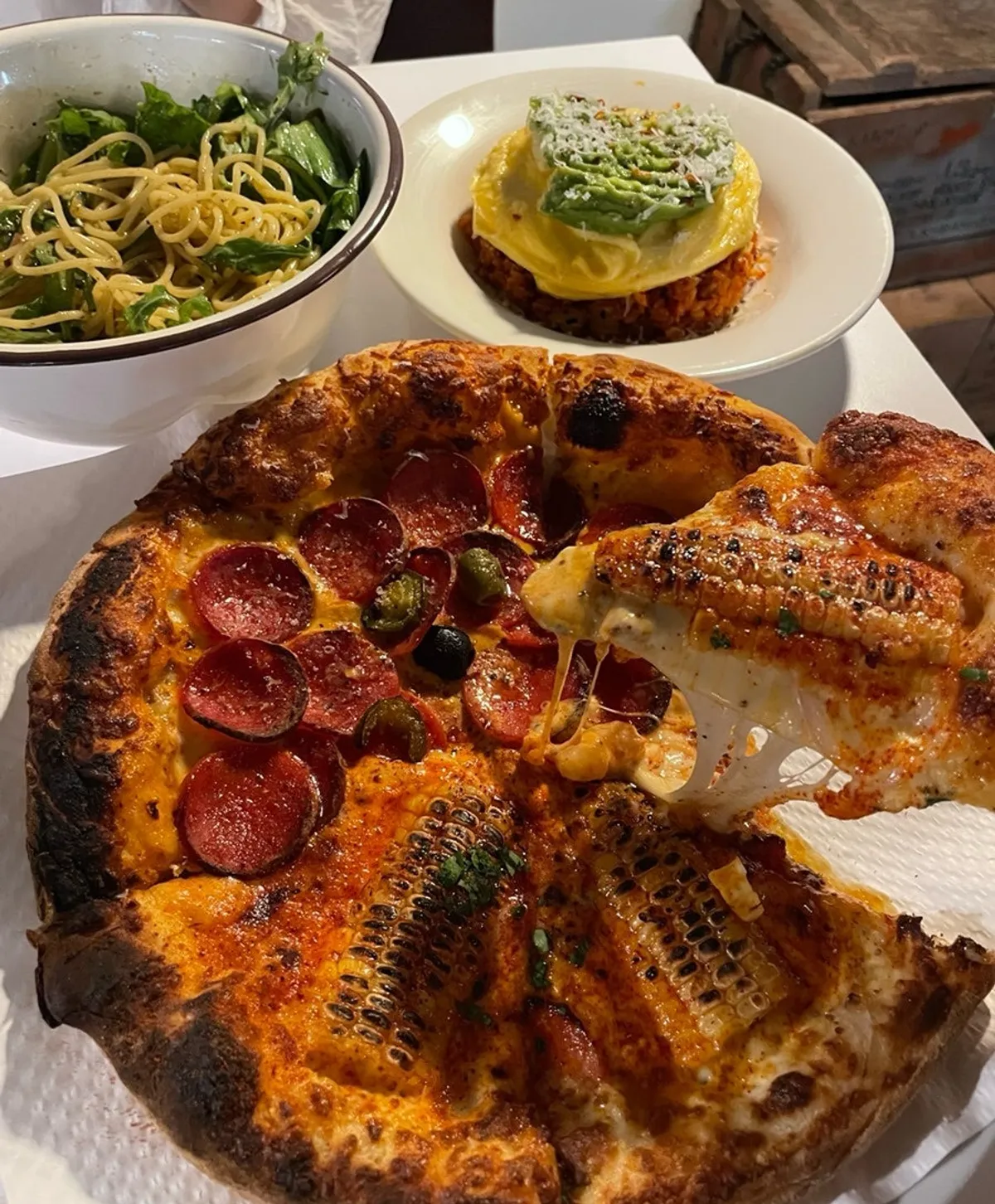 Table spread with pizza, pasta, and kimchi fried rice together
