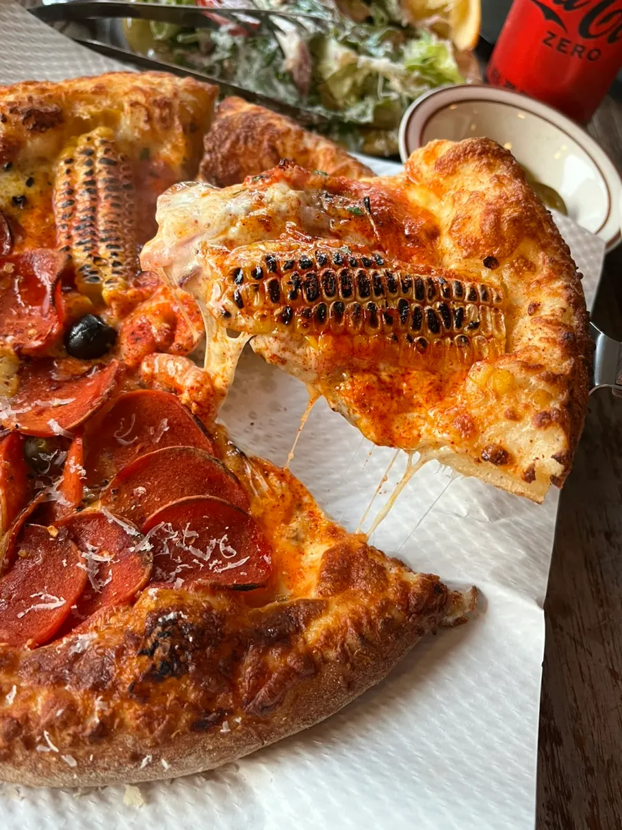 Corn and pepperoni half-and-half pizza cut into 6 slices