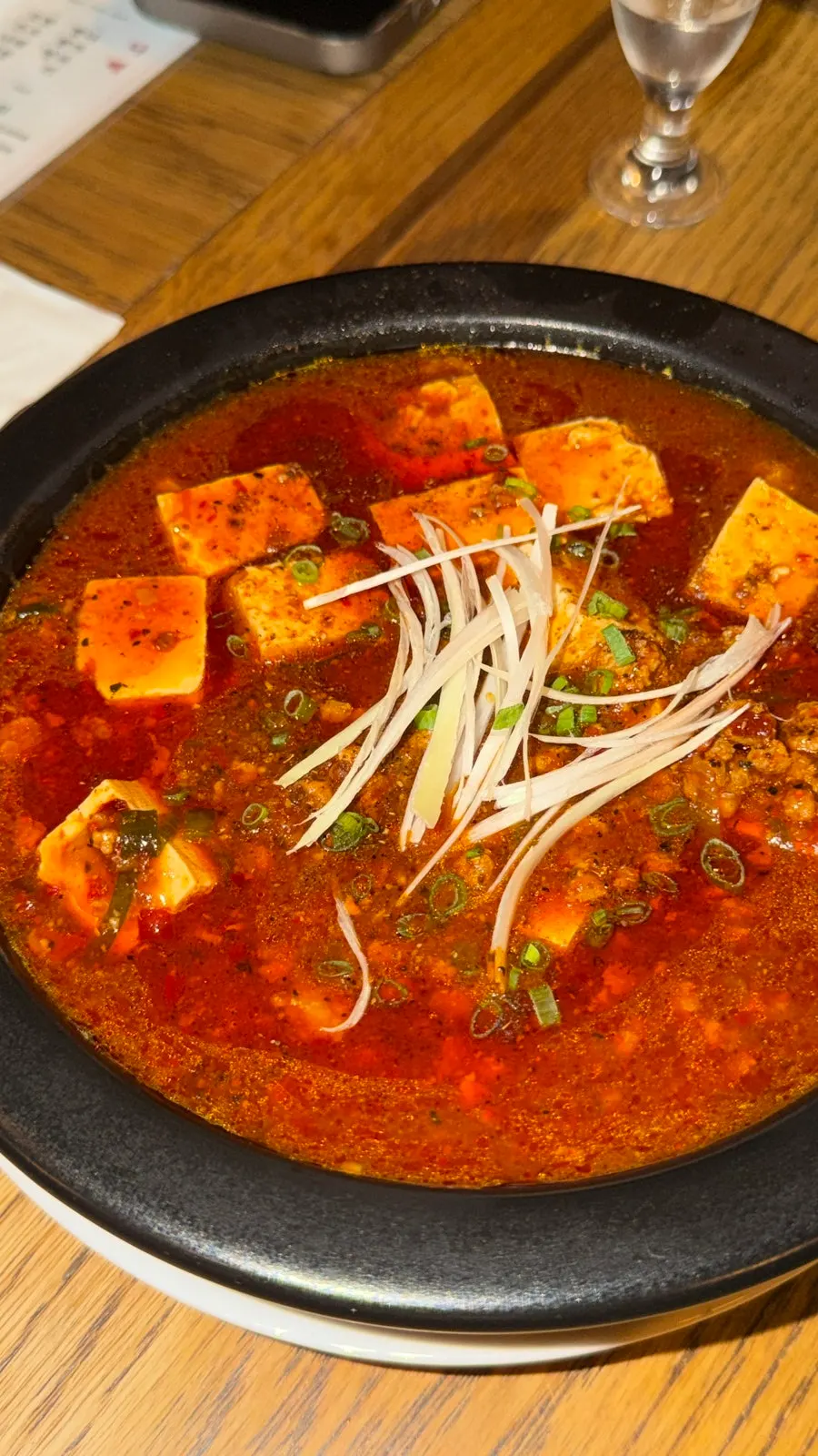 A bowl of mapo tofu with a rich red sauce