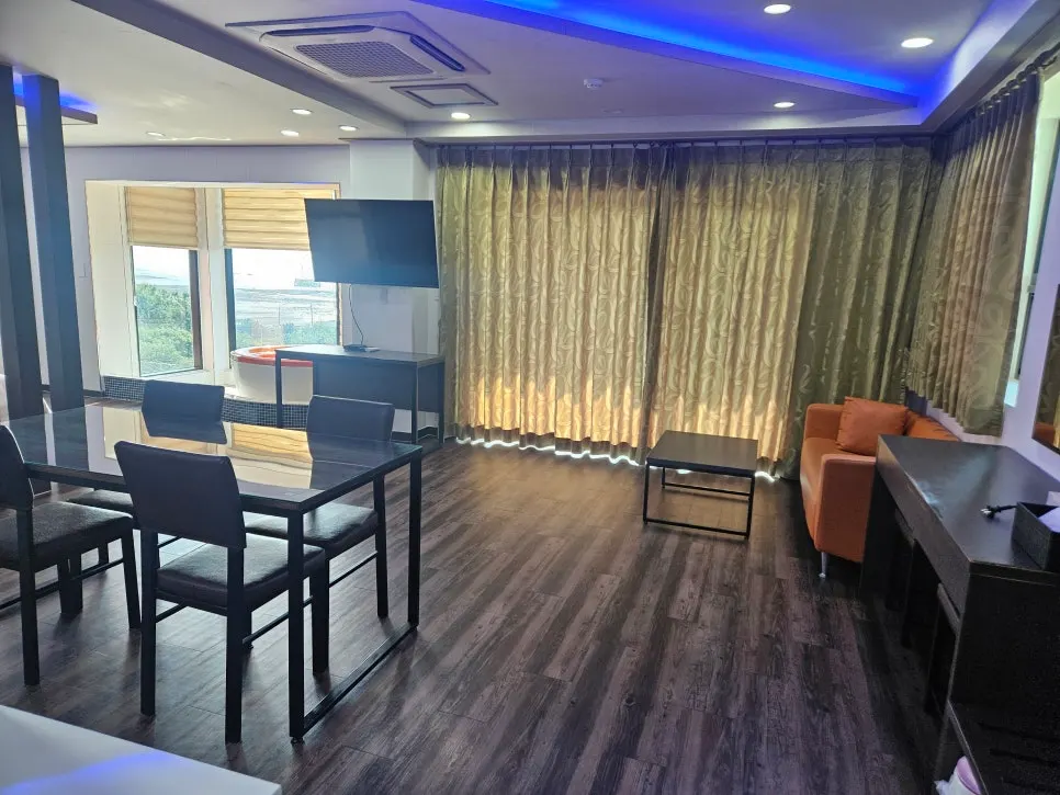 Spacious spa room living area with dining table and sofa
