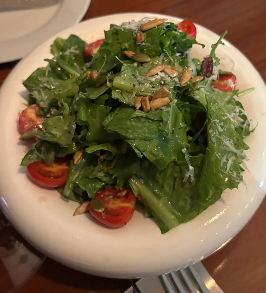 Salad and wine glasses together on the table