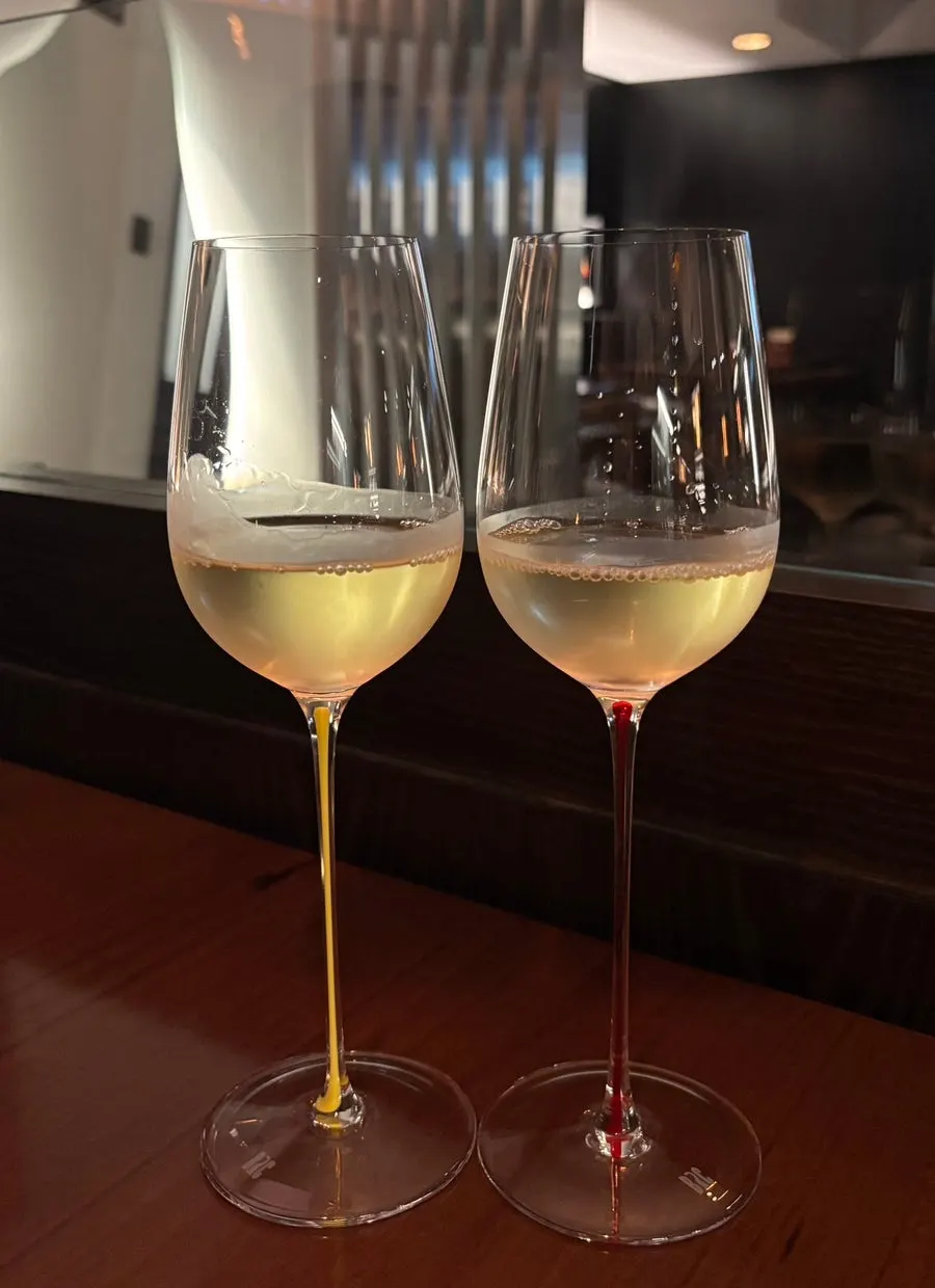 A glass of house white wine under soft lighting