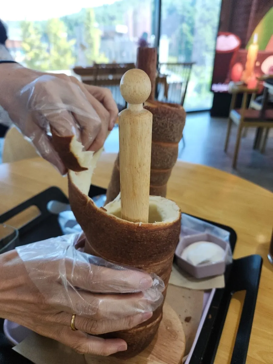 Hands tearing apart the chimney bread