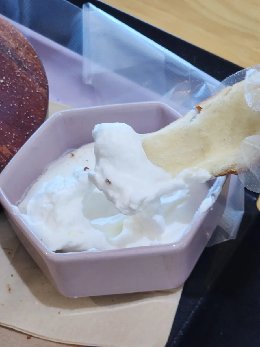 A piece of chimney bread dipped in whipped cream