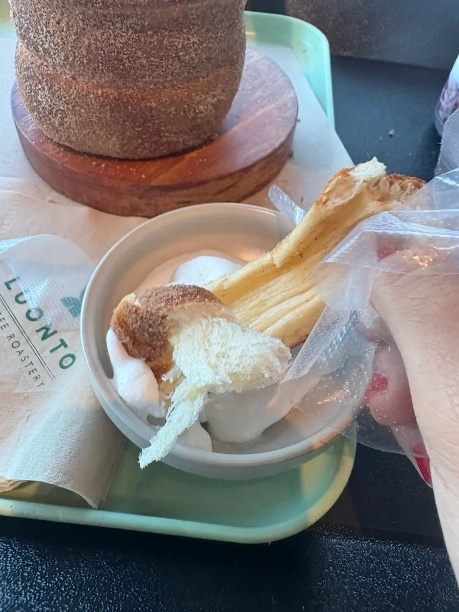 A piece of chimney bread dipped in whipped cream
