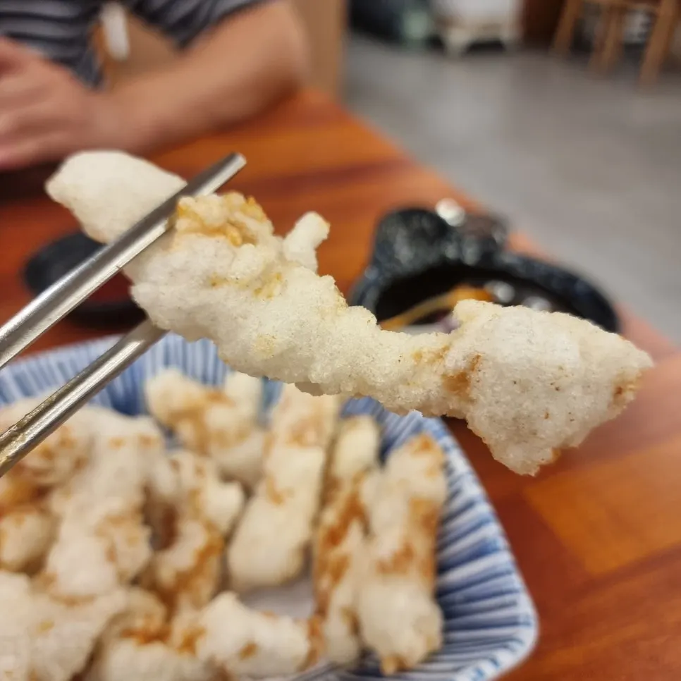 Tangsuyuk pieces compared in size next to chopsticks