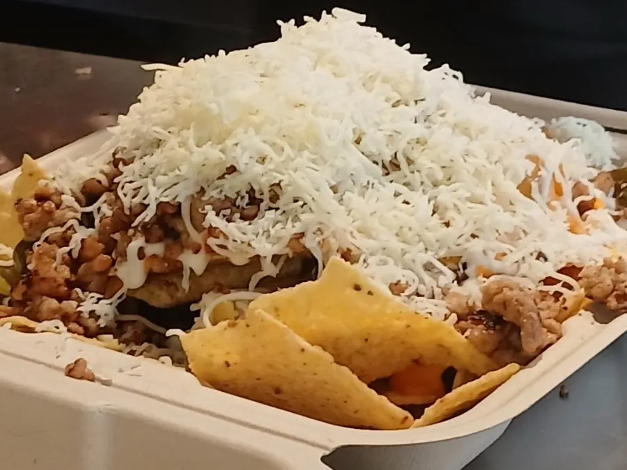 Scooping up cheese topping along with the nachos