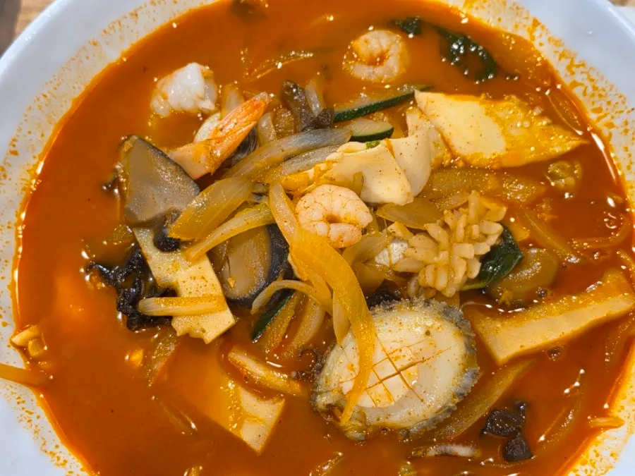 Sweet and sour pork dipped into chili sauce
