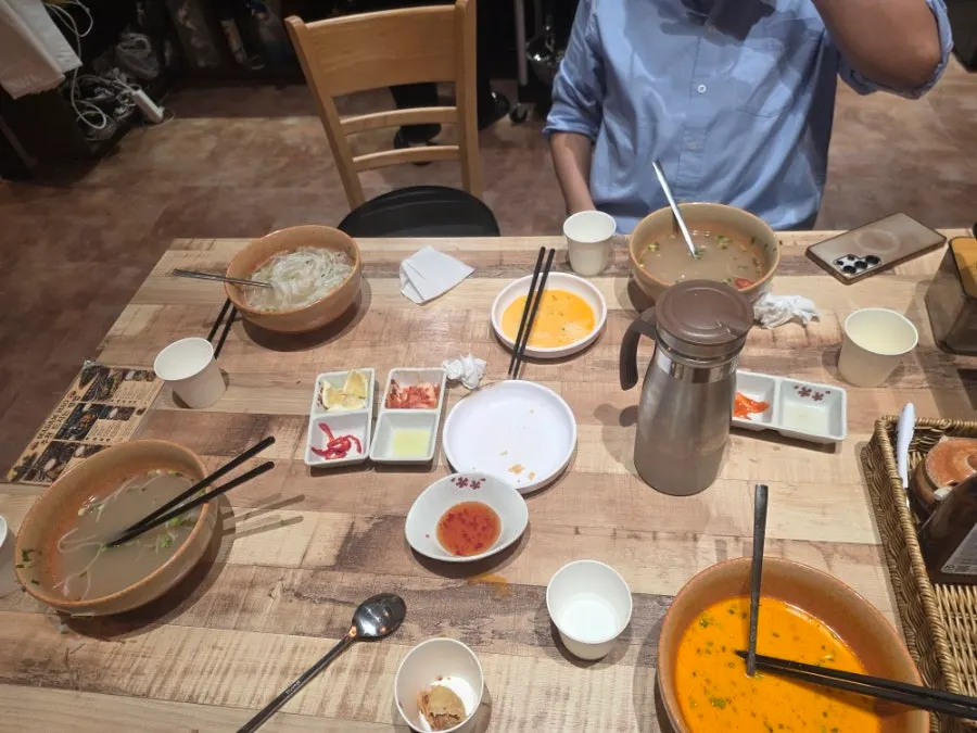 Self-service corner with small plates, side dishes, and a drinks fridge