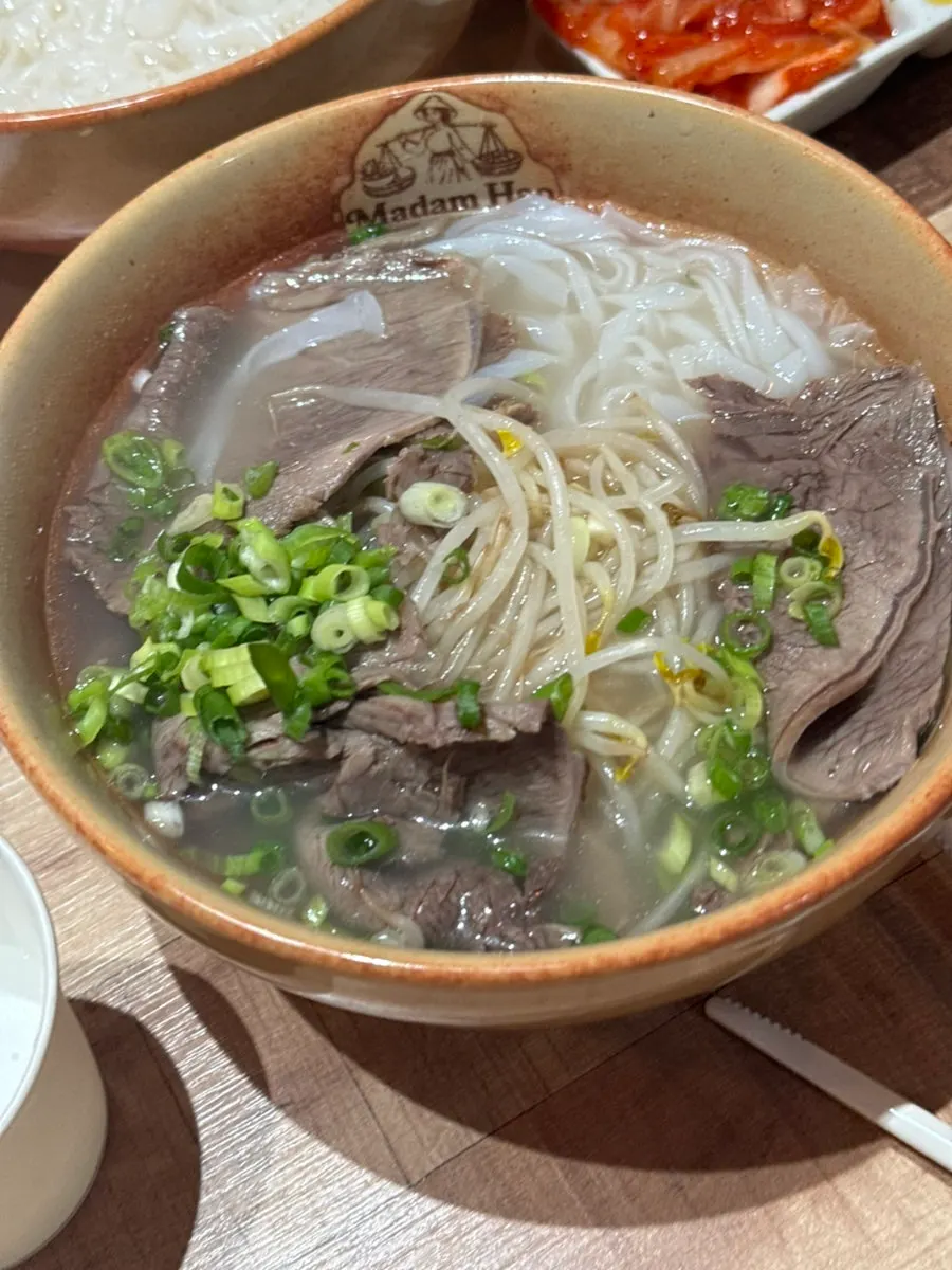 Table spread of ordered beef brisket pho and beef fried rice