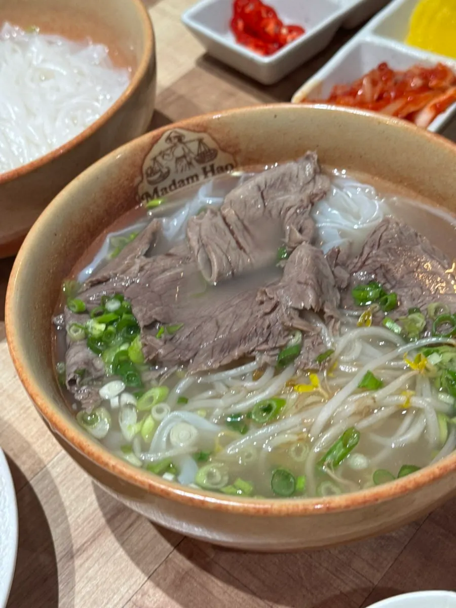 Generous portion of noodles and broth in the beef brisket pho
