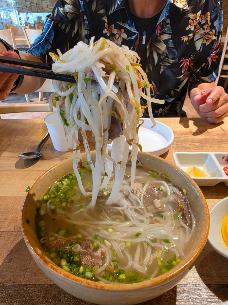 Broth of the beef brisket pho served in a large bowl