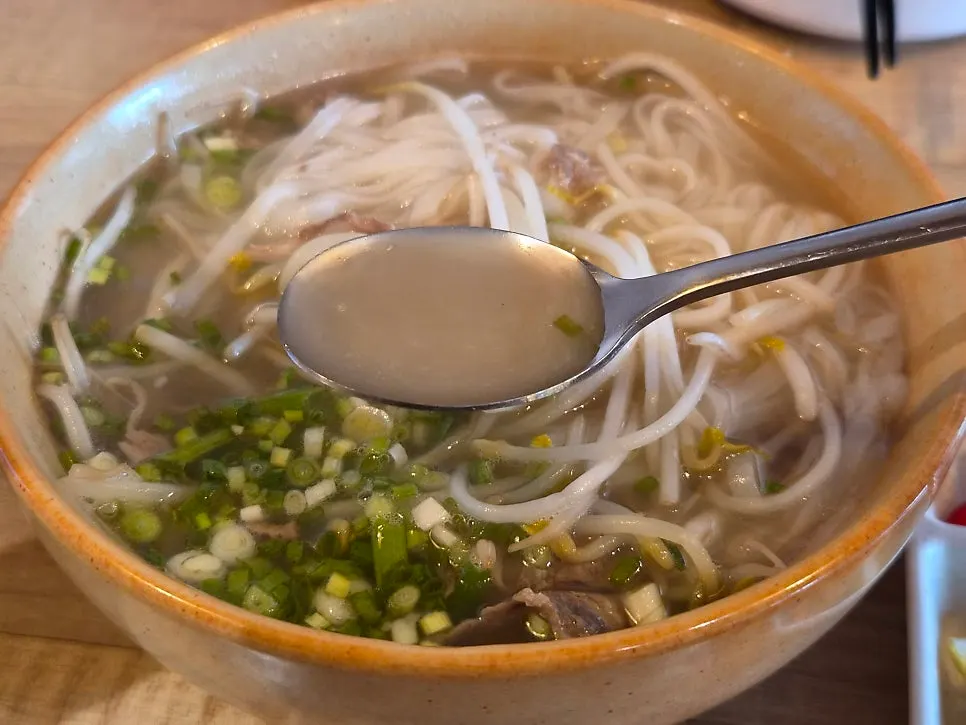 A spoonful of rich pho broth
