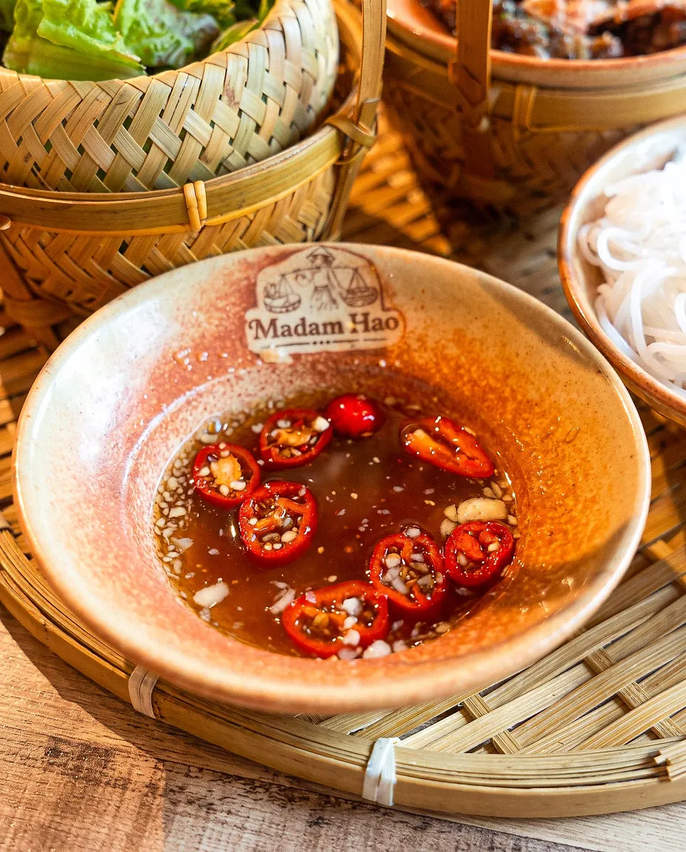Dipping noodles and meat into nuoc mam sauce