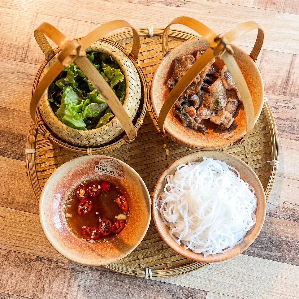 Dipping a bun cha lettuce wrap into sauce