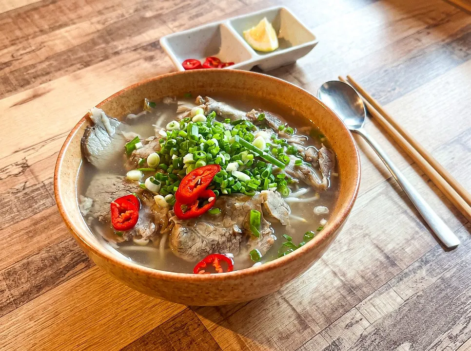 Scooping up beef brisket pho broth