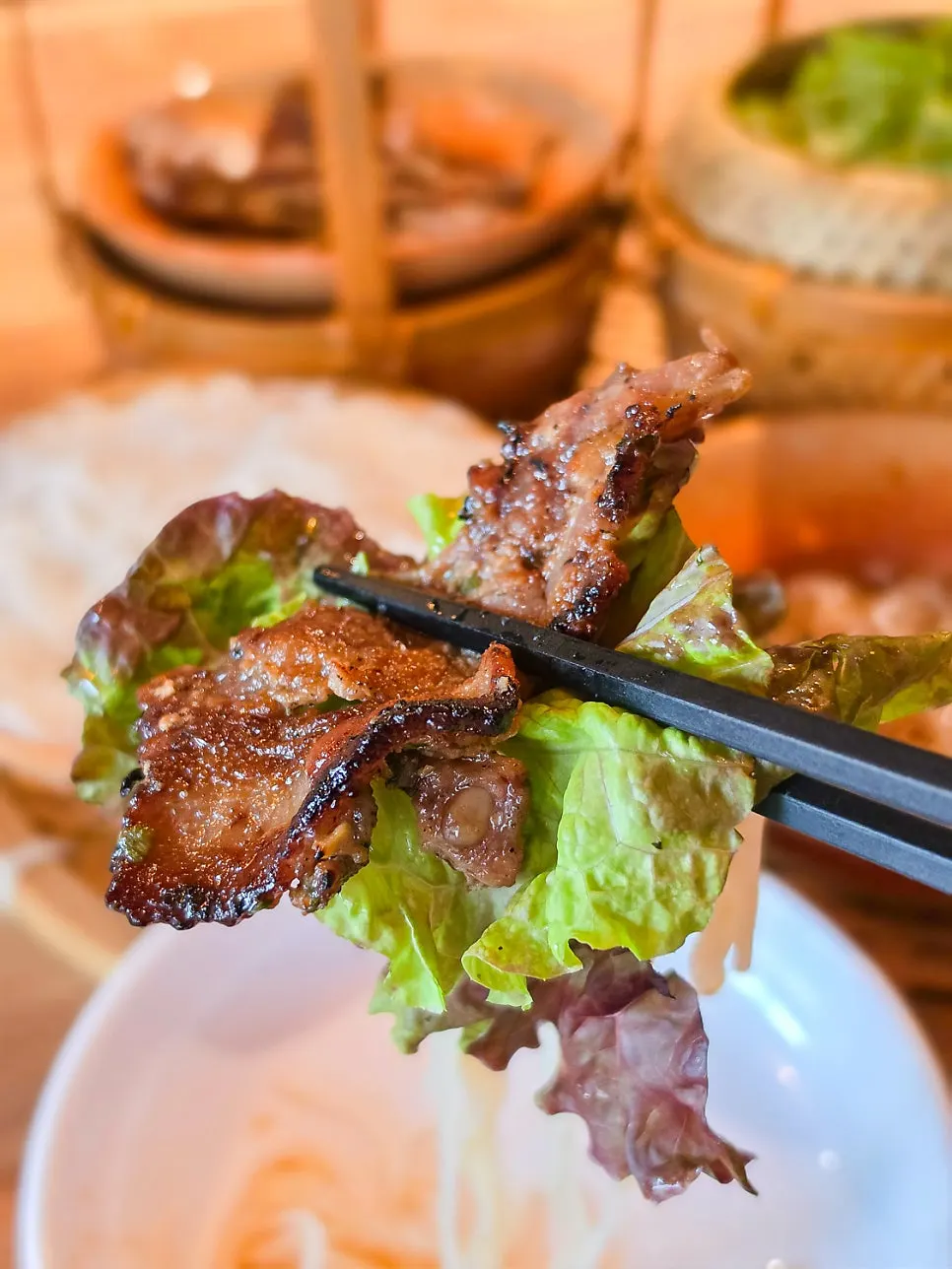 A chopstick-full of rice noodles dipped in sauce