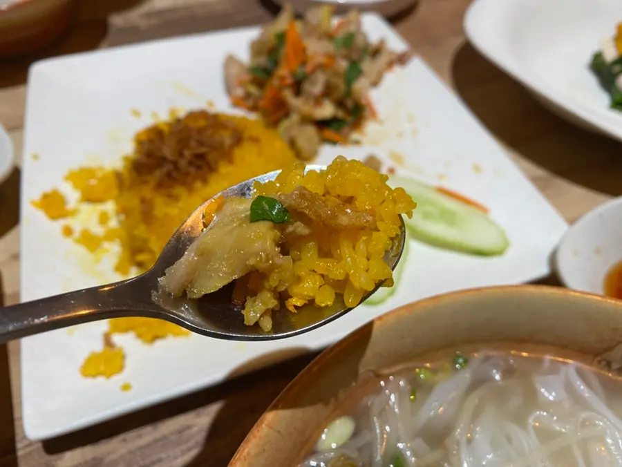 A spoonful of fried rice topped with chicken