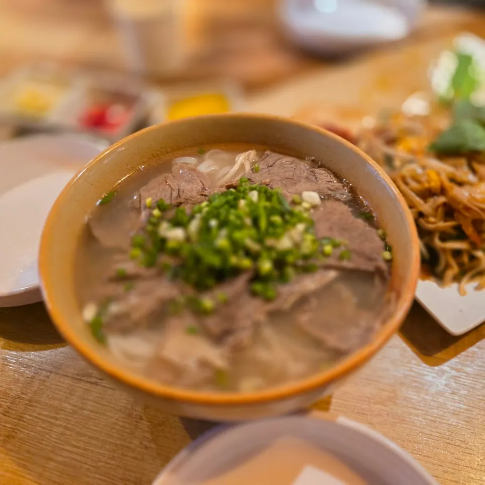 A bowl of pho nam topped with beef brisket