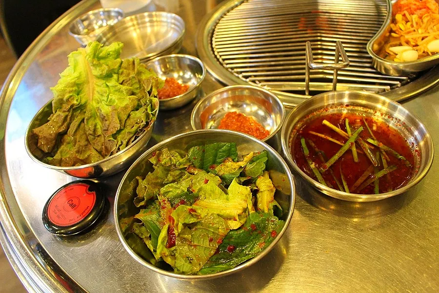 Basic table setting with fresh kimchi salad and lettuce wraps