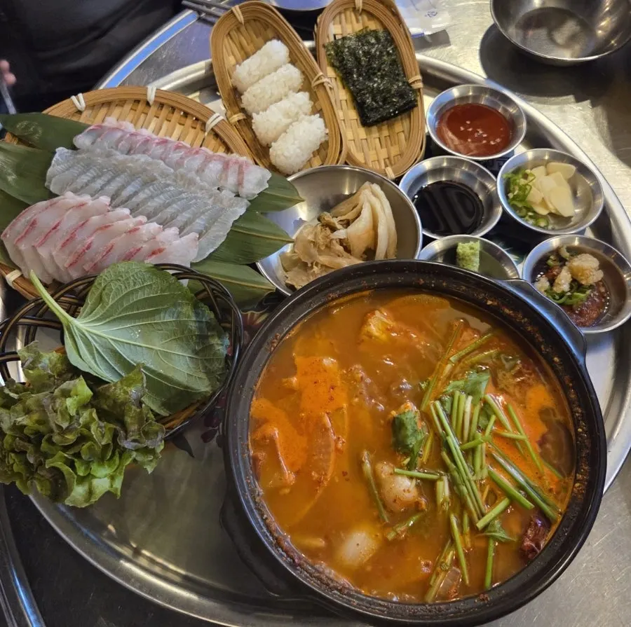 Live fish sashimi platter set with sashimi, sushi, and spicy fish stew