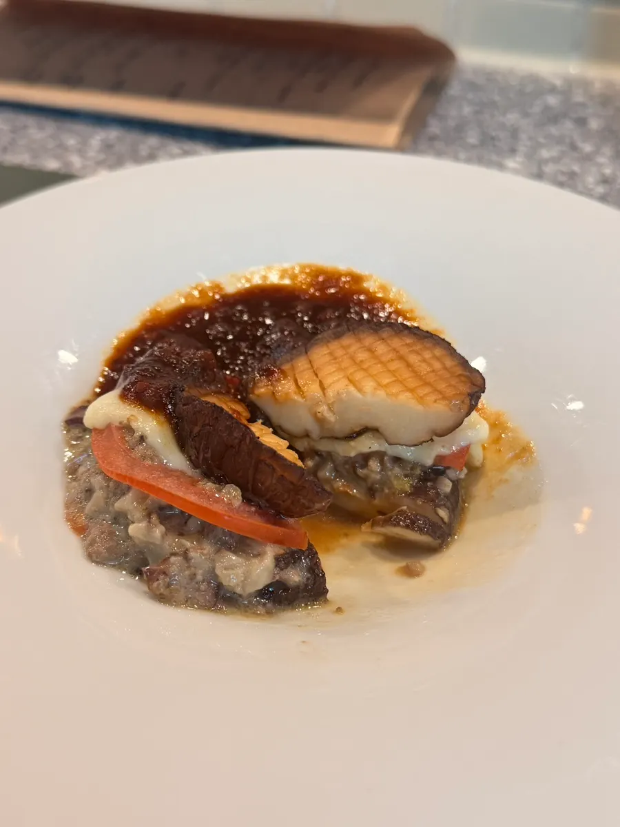Mushroom lasagna topped with white ragu and mozzarella