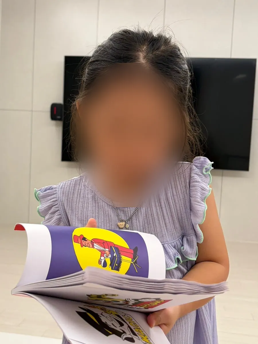집에서 마술책으로 마술 연습하는 아이