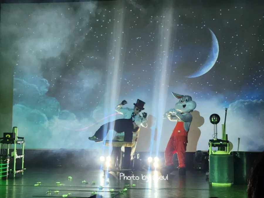 A child on stage participating alongside the magician