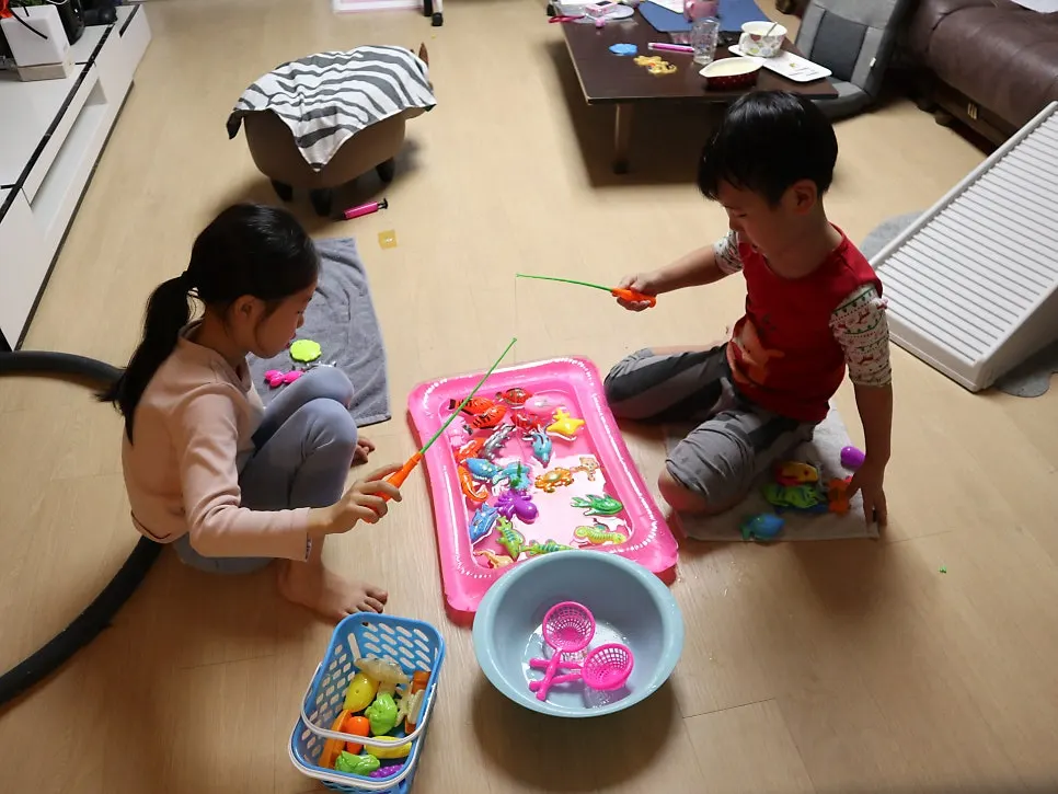 Children playing a magnetic fishing game