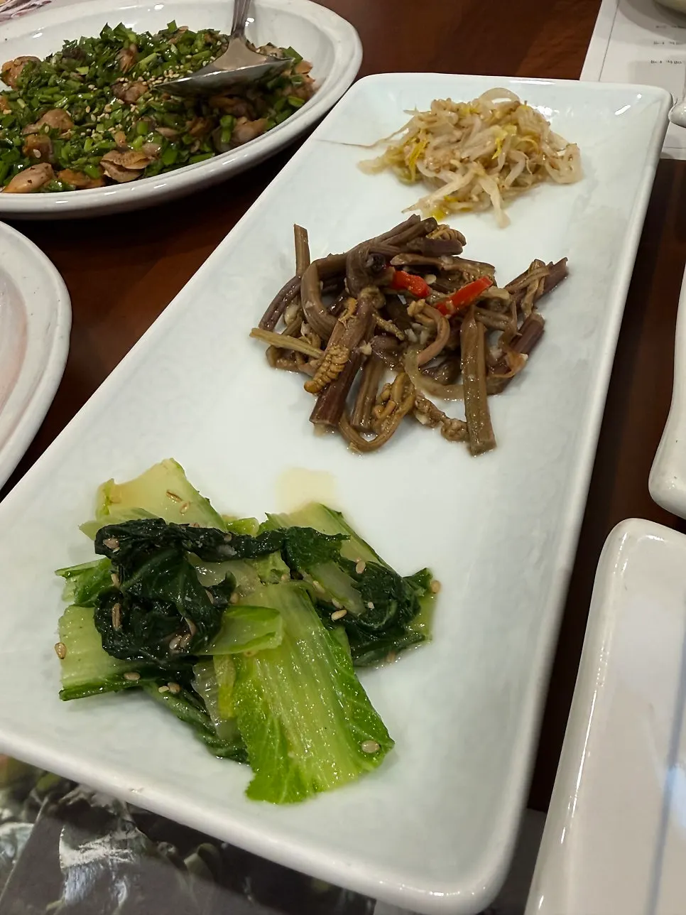 Neatly presented Korean side dishes including spicy pork
