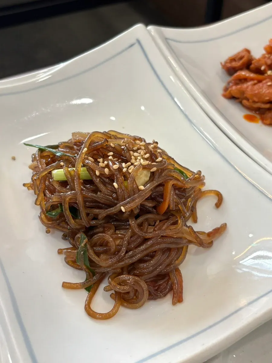 Japchae, stir-fried pork, and leafy greens
