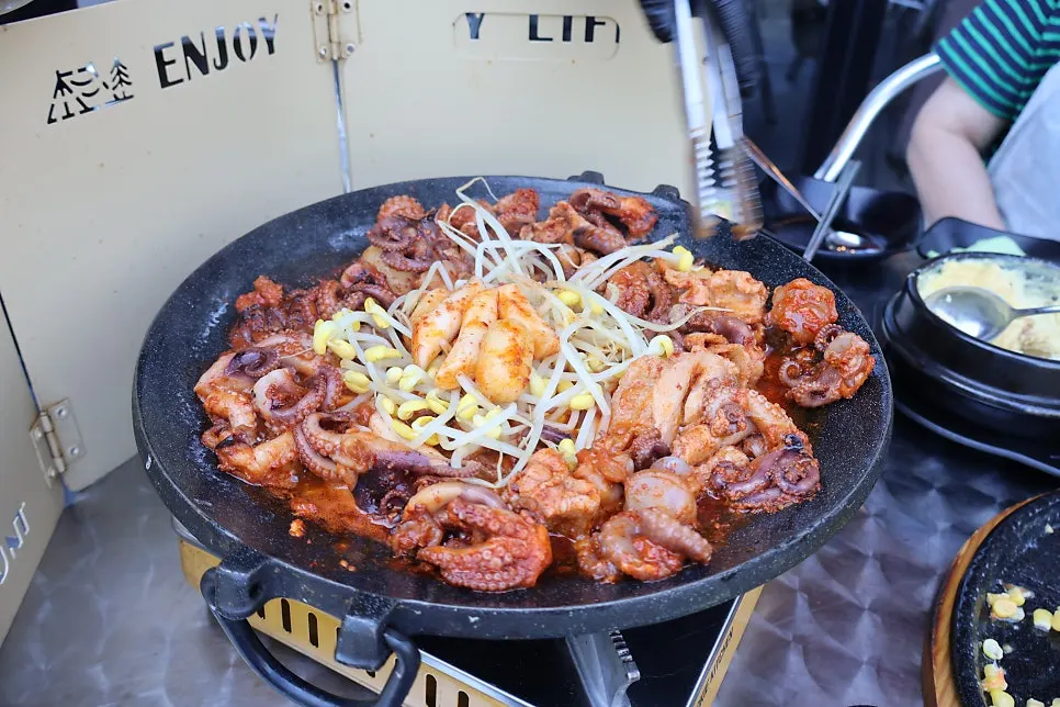 Staff cooking webfoot octopus on the griddle