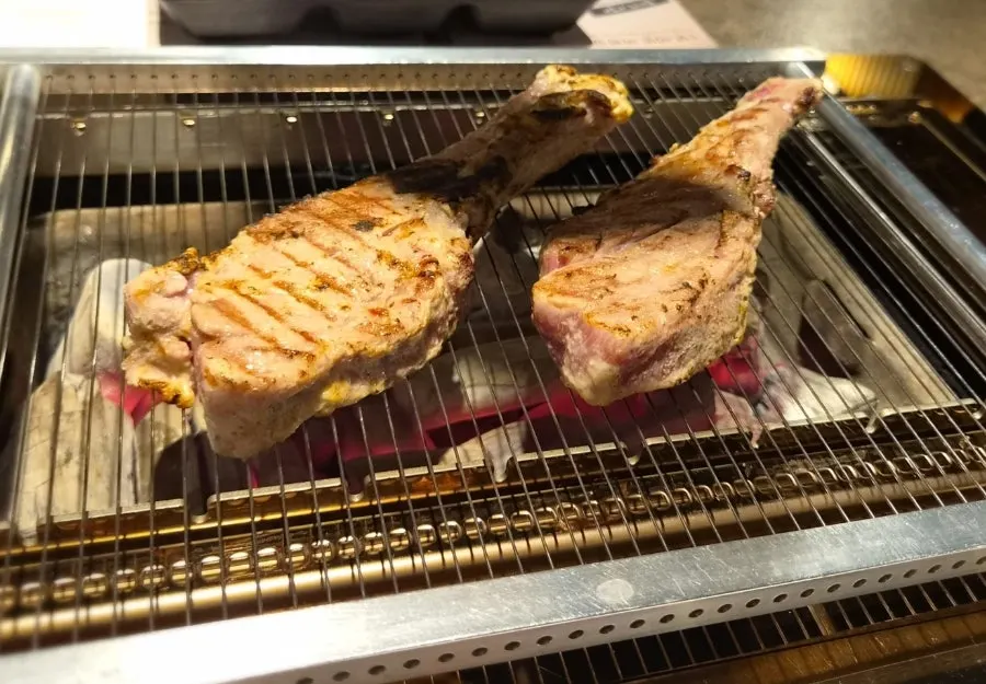 Lamb ribs being finished over charcoal