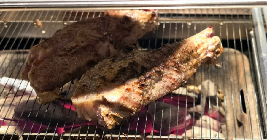Lamb shoulder rack grilling over charcoal