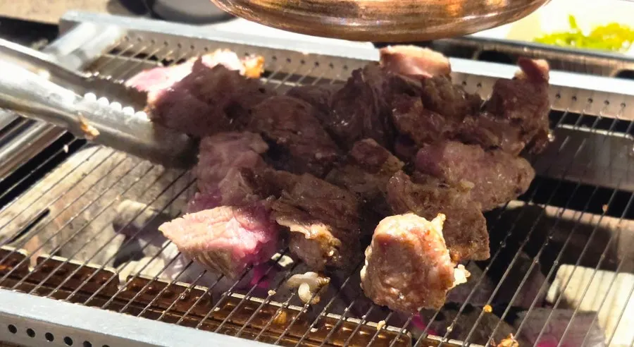 Lamb being grilled tableside by staff