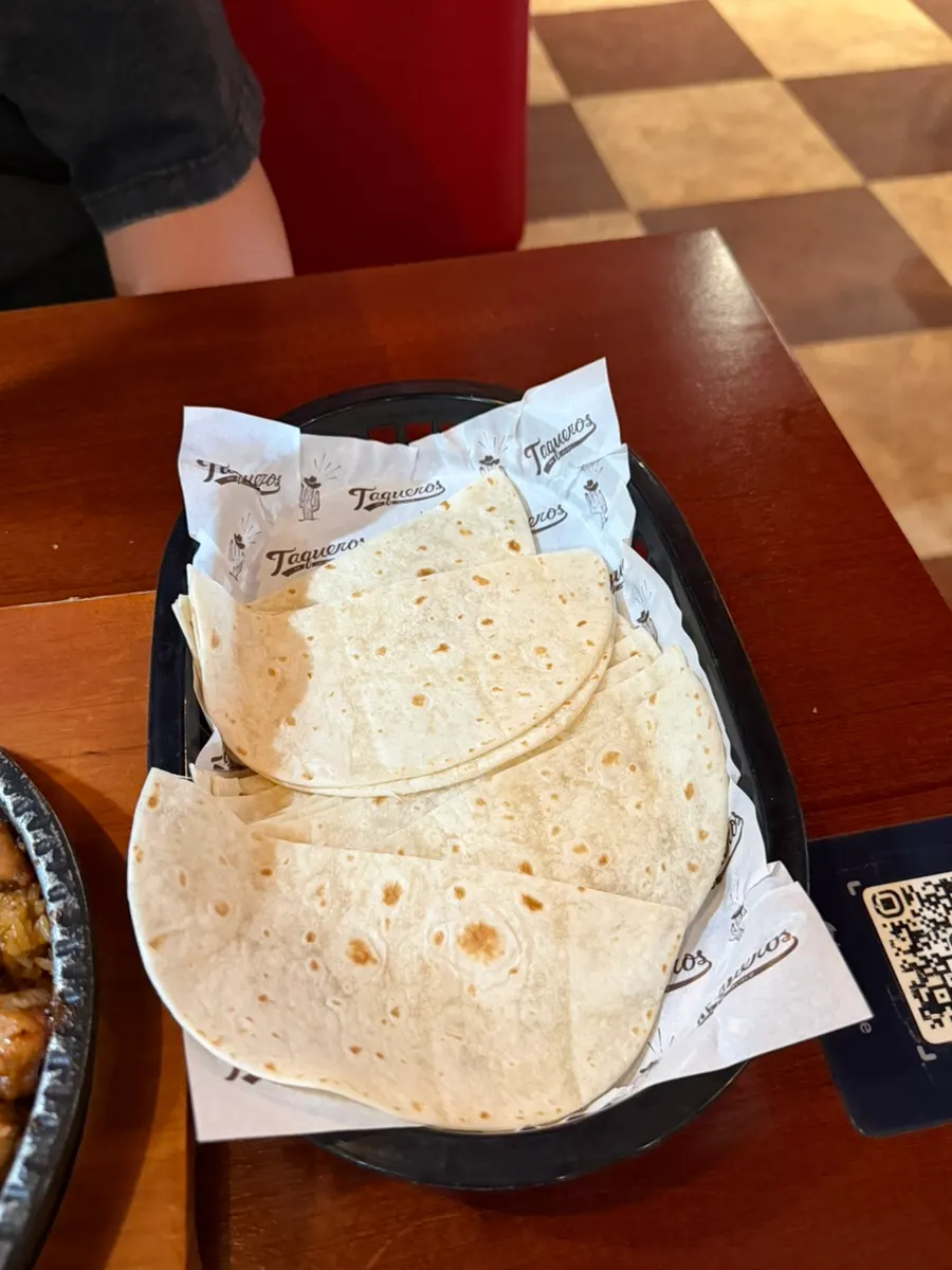 A tortilla piled high with fajita ingredients, ready to bite