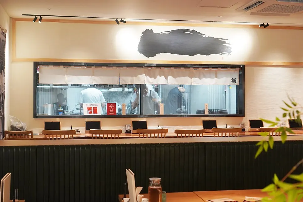 Open kitchen grilling eel over charcoal