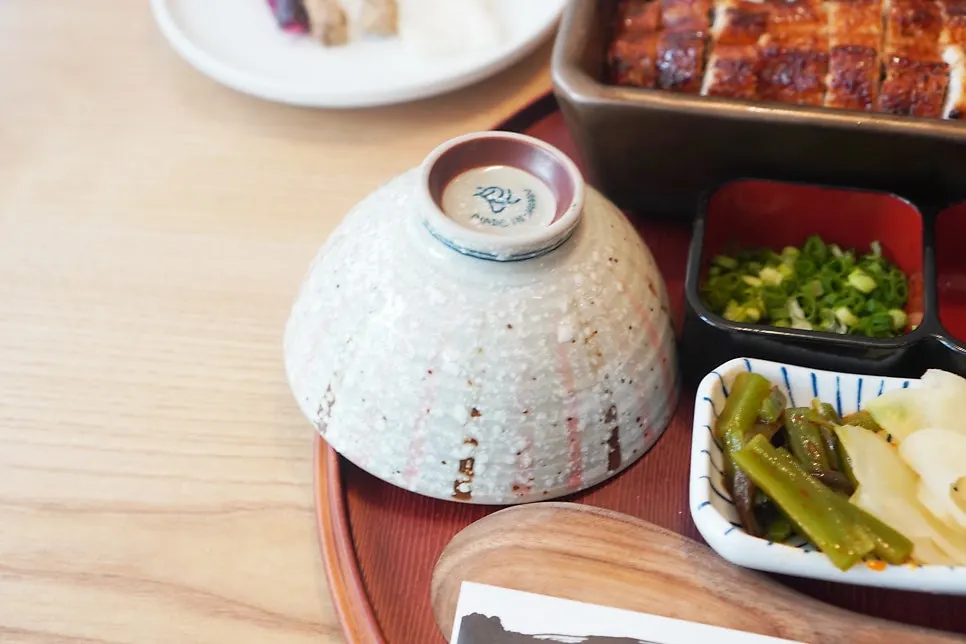 A piece of eel and rice scooped with a paddle