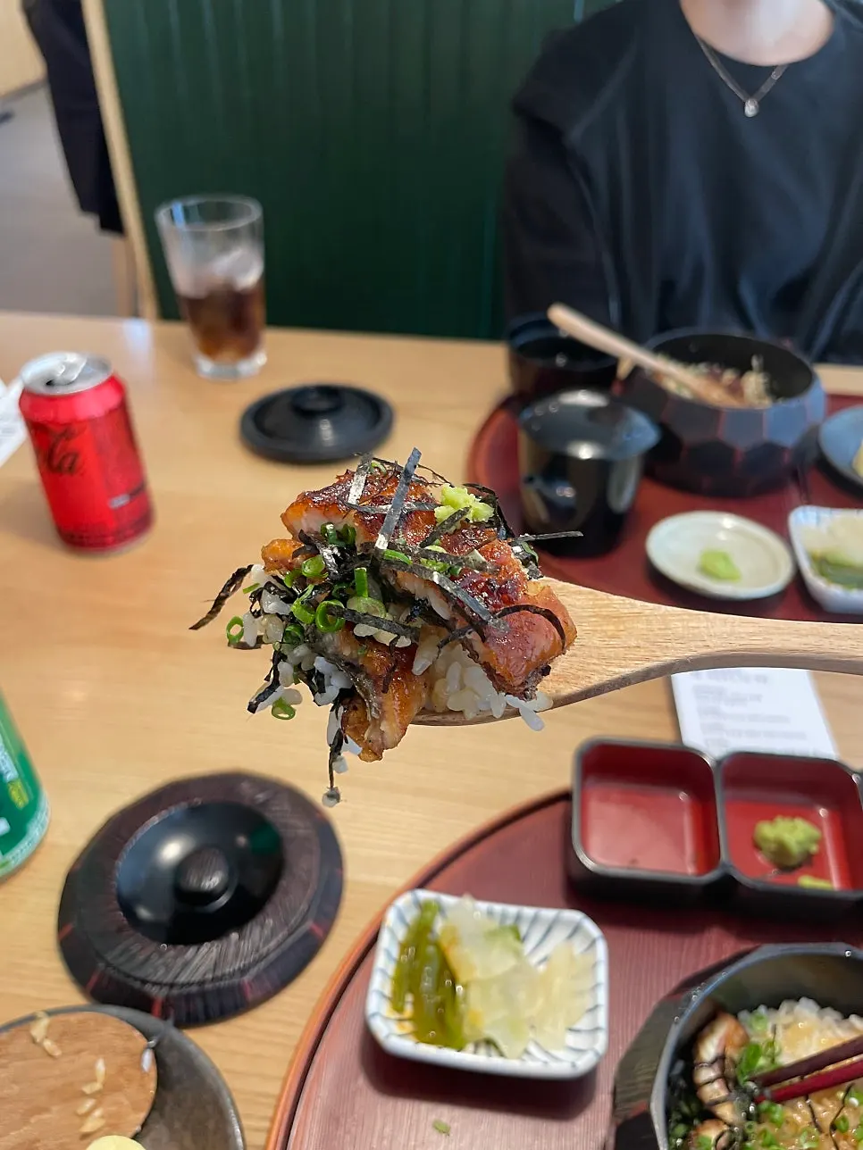 A bowl of eel rice scooped out with a wooden paddle