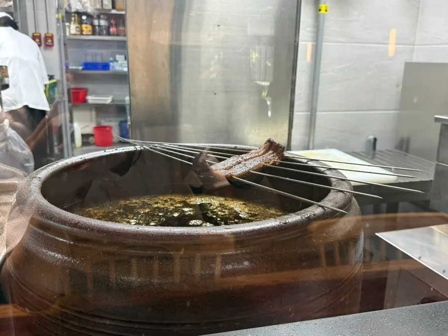 Close-up of eel grilling over charcoal