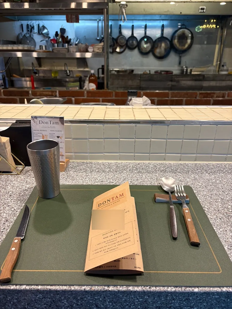 Bar-style seating surrounding the open kitchen at Don Tamguso