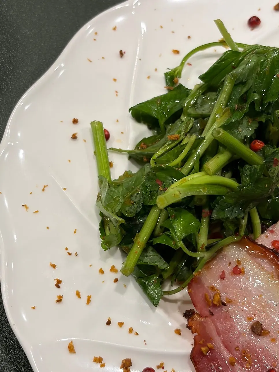 Seasoned minari served alongside the pork belly