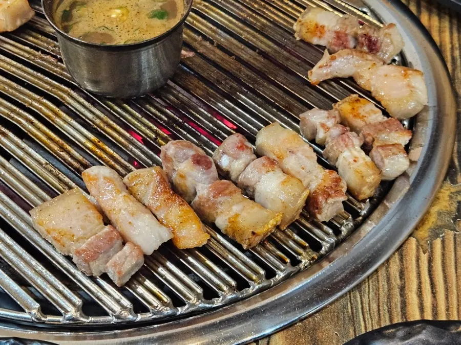 Ogyeopsal grilled at a charcoal table