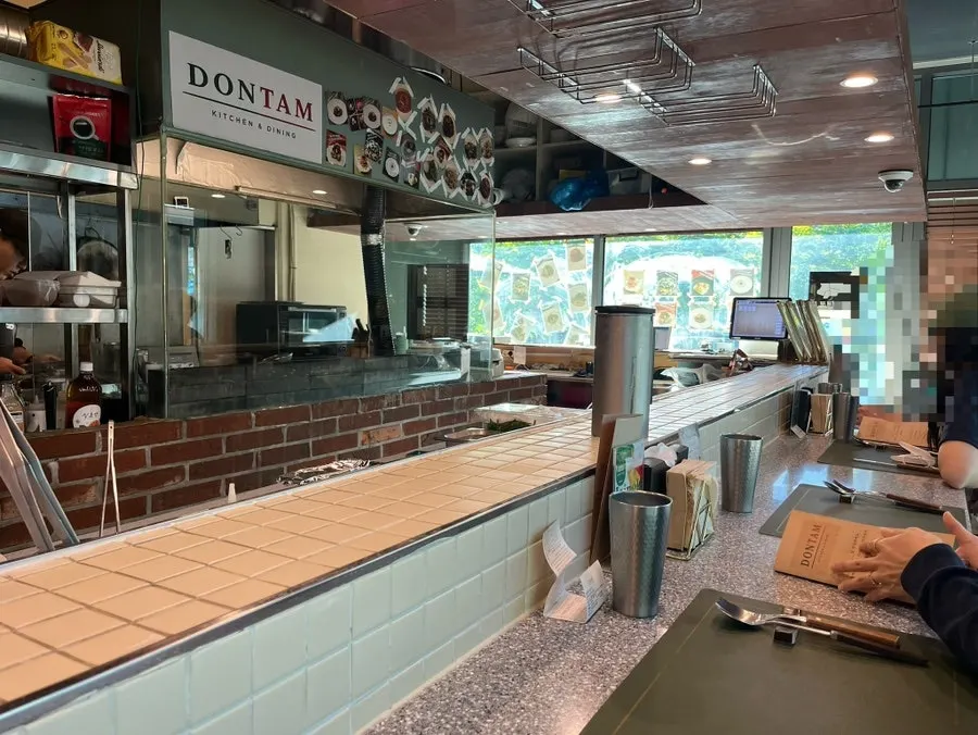 Interior of Don Tamguso with open kitchen and bar seating