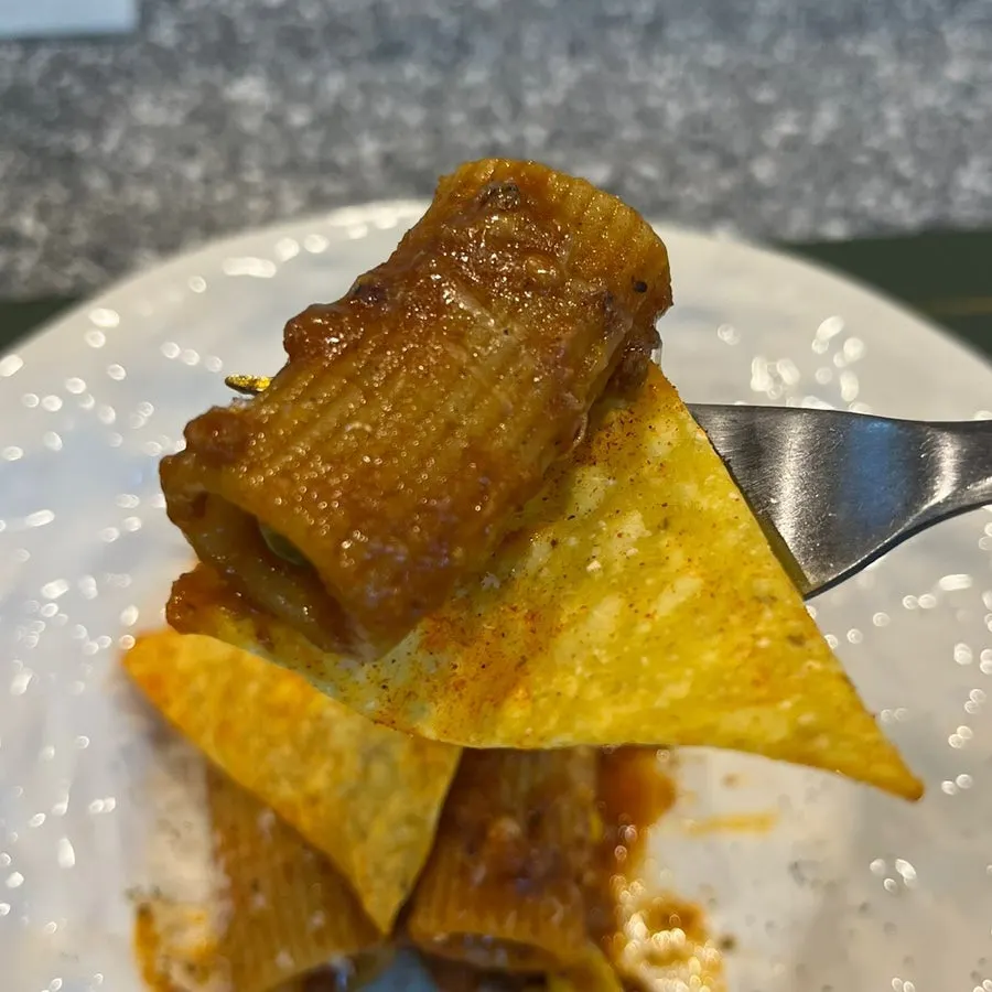 Con carne rigatoni served over nachos