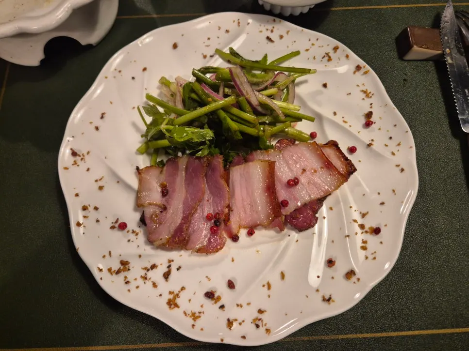 A plate of oven-roasted pork belly with minari salad