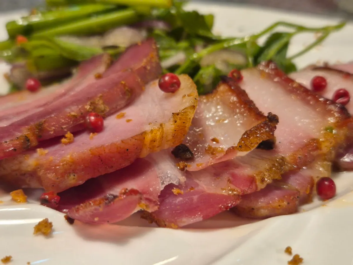 Pork belly and minari salad topped with red pepper