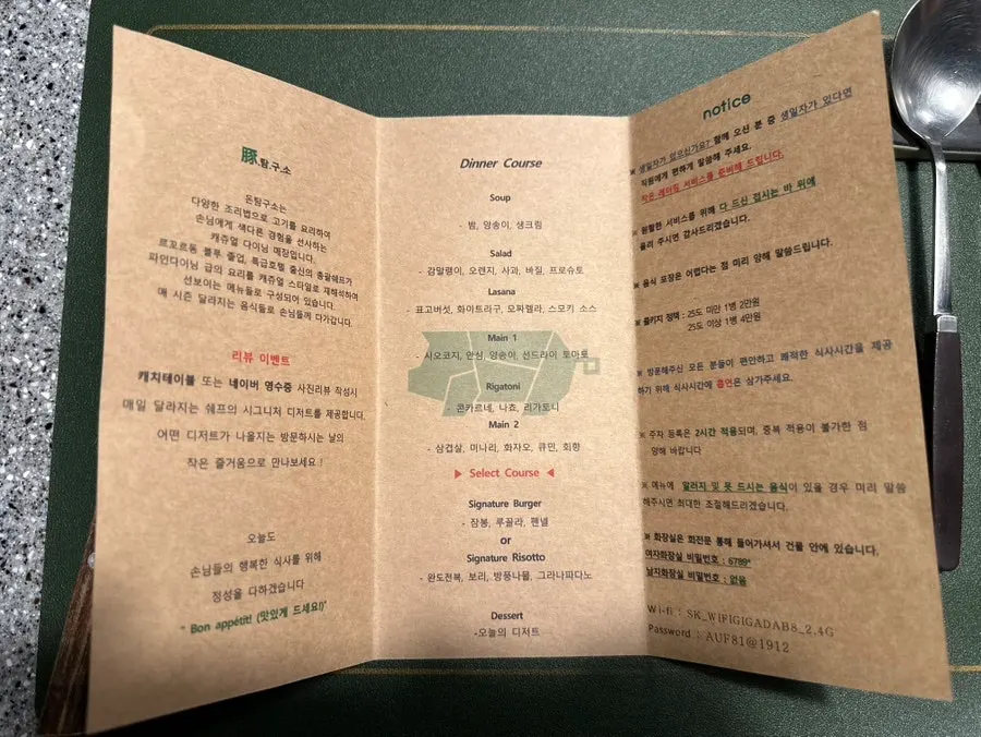 코스 메뉴 구성이 적힌 안내서 펼친 모습